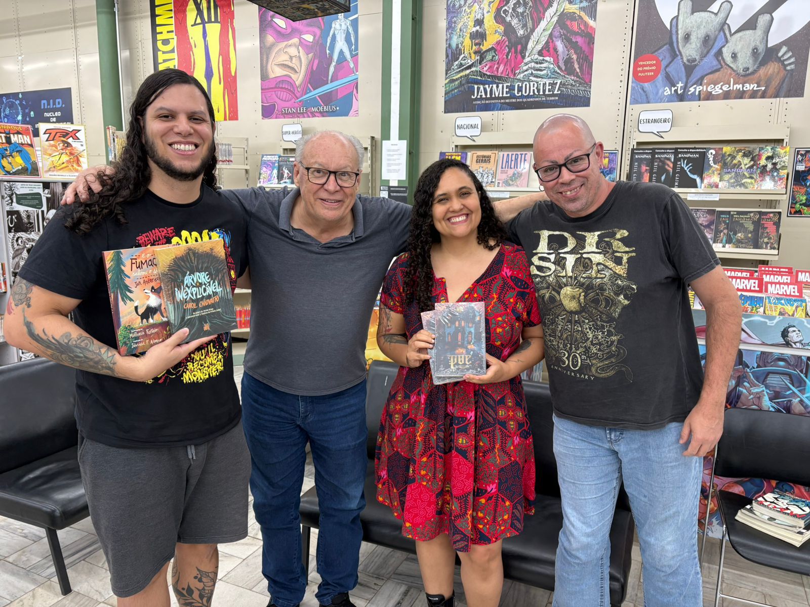 Bruno Romão e Nathalia Xavier realizam a doação de exemplares de livros dos quais participam, contribuindo para o acervo da Biblioteca Municipal